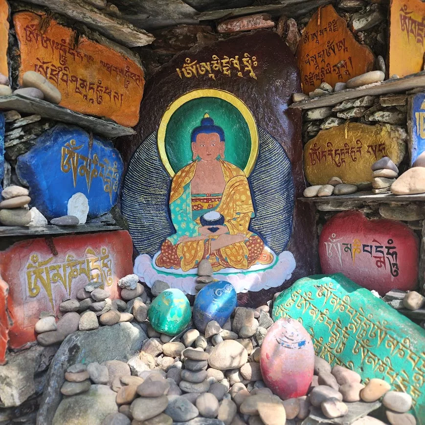 Altar com imagem de Buda e pedras pintadas com mantras